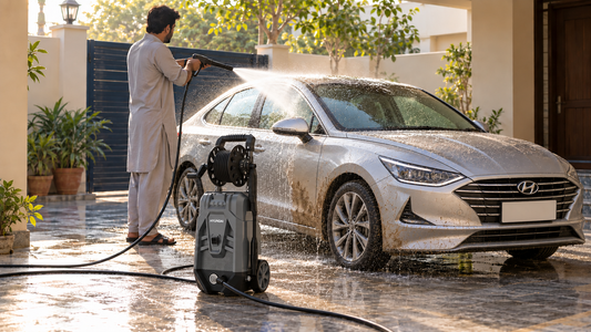 Man rinsing dust off a car with a Hyundai pressure washer in the porch of a Pakistani home